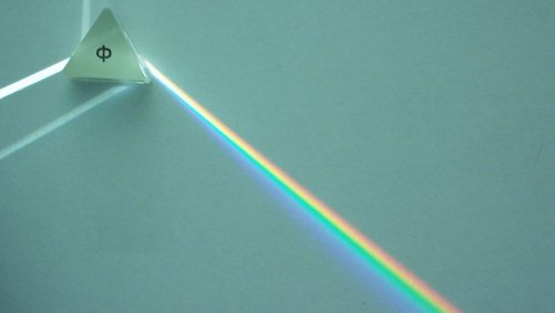 Je nach Wellenlänge wird Licht, das durch ein Prisma fällt, unterschiedlich stark gebrochen.