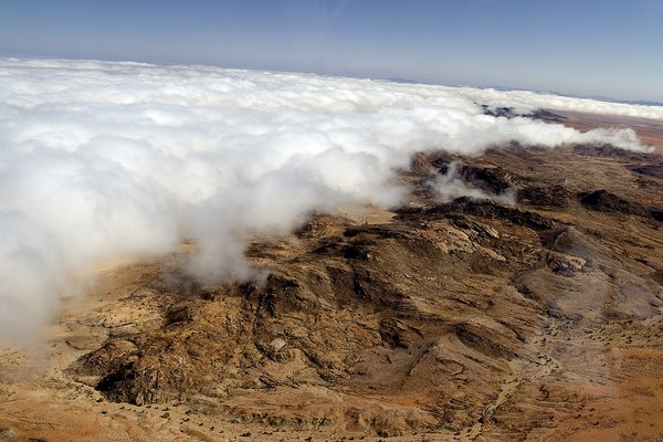 Luftaufnahme einer Wüstenlandschaft, im linken Teil ein Nebelfeld