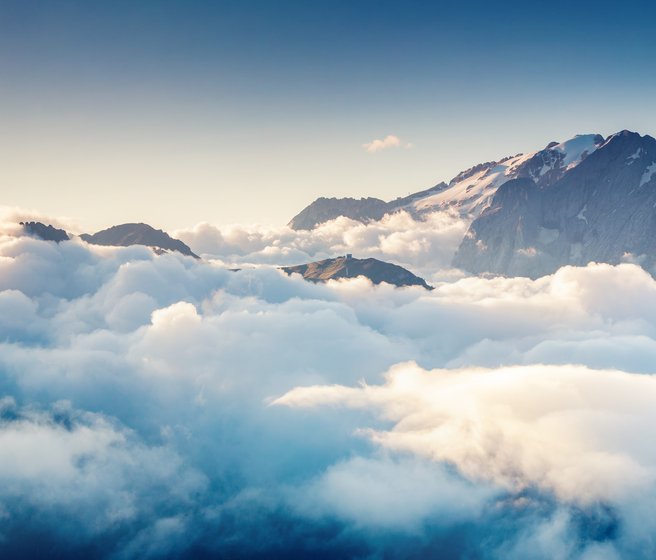 Montagne émergeant des nuages avec du ciel bleu au-dessus