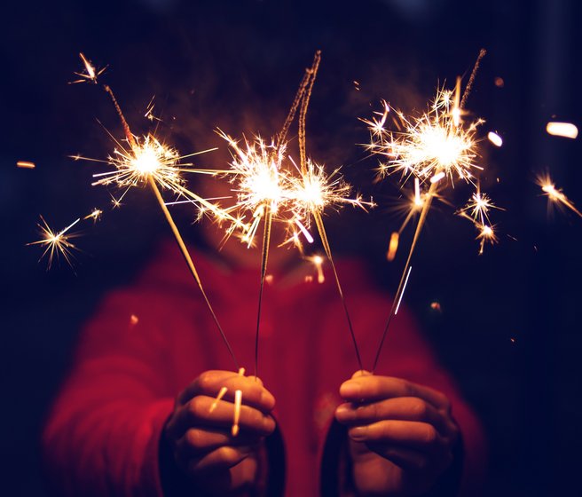 Enfant tenant des cierges magiques dans ses mains