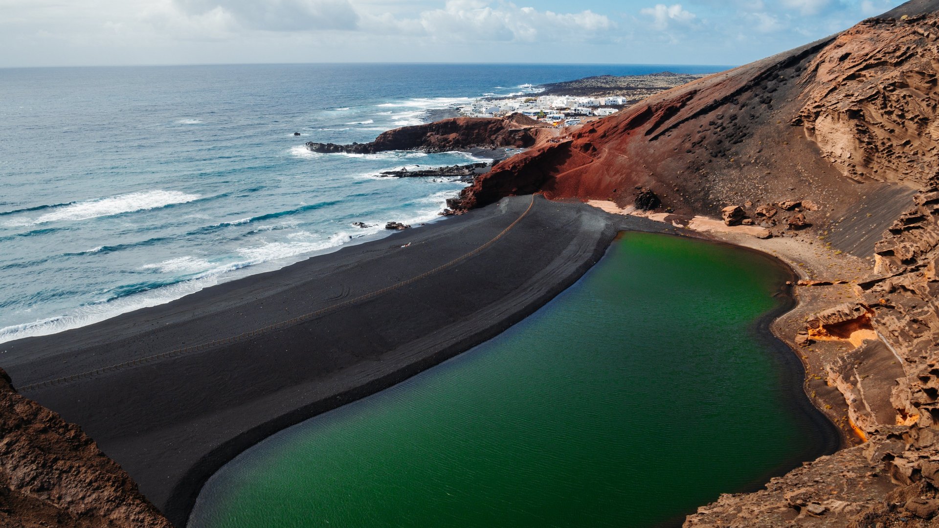 Grüne Lagune an einem schwarzen Strand