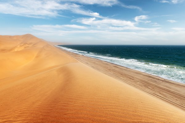 Orangefarbene Düne, die zum Meer abfällt