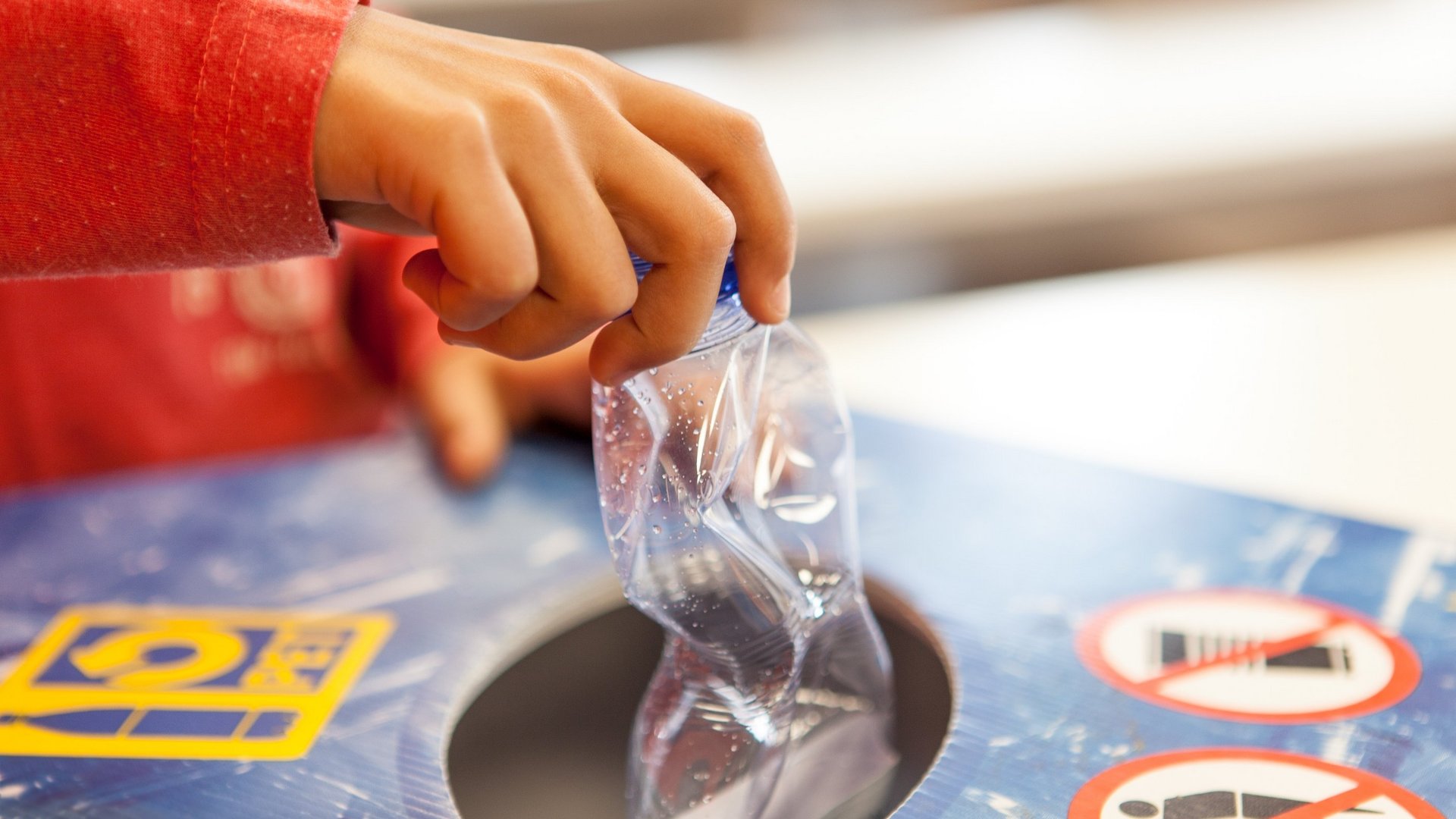 Un enfant ramène une bouteille PET usagée dans un point de collecte