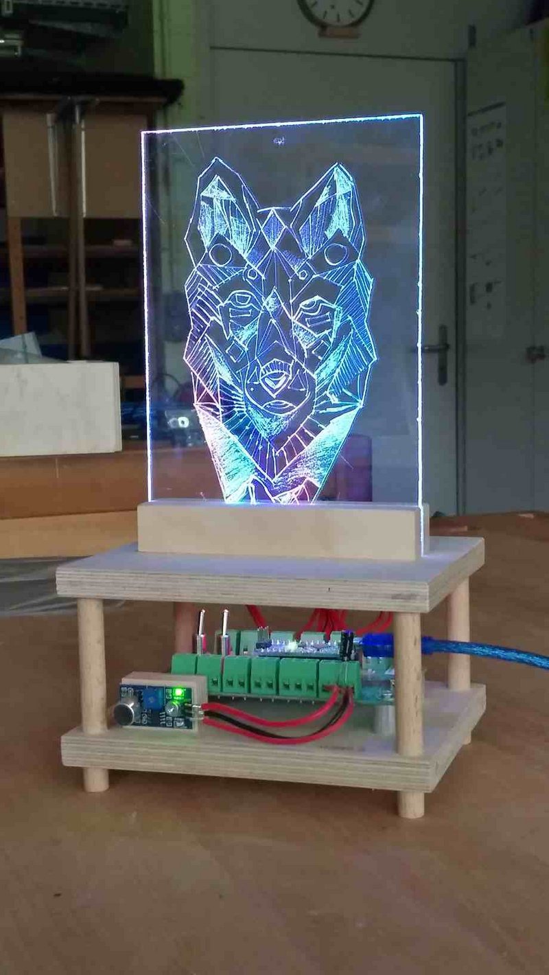 Plexiglasscheibe mit eingraviertem Wolfsgesicht, das mittels eingebauter LEDs leuchtet