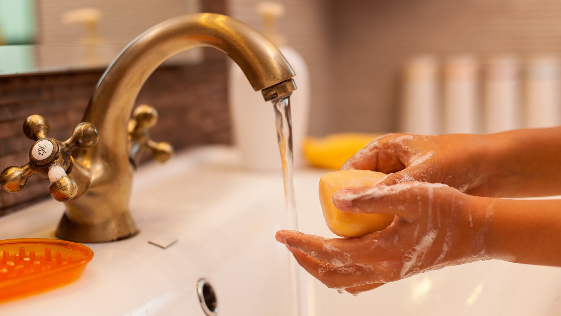 Mains avec du savon sous un jet d'eau courante