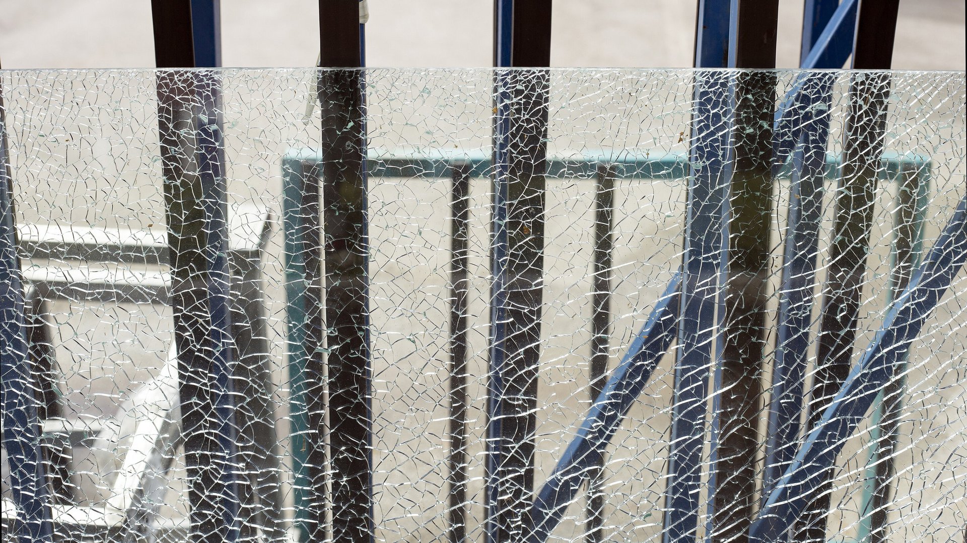 Zersprungene Scheibe aus Sicherheitsglas vor einer Metallkonstruktion