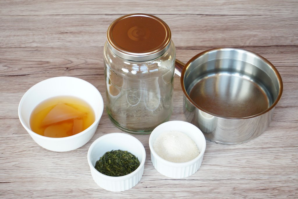 Einmachglas, Kochtopf mit Wasser, Kombucha-Kultur, Gr&uuml;ntee und Zucker