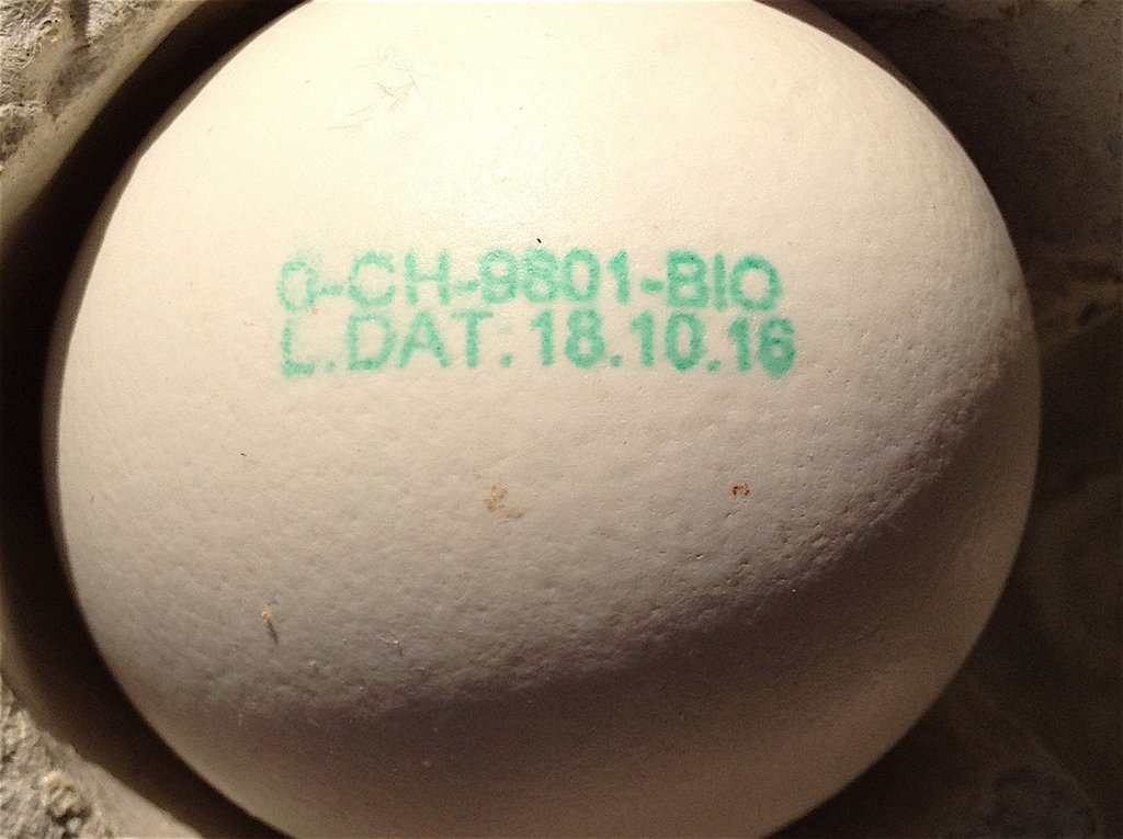 Gros plan d’un œuf blanc avec tampon de date de ponte