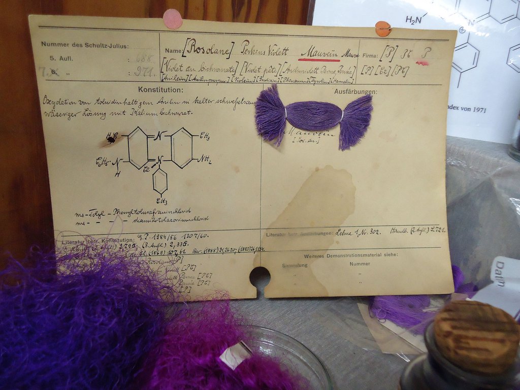 Handgeschriebene Karte mit der chemischen Formel von Mauvein und einer violetten Farbstoffprobe