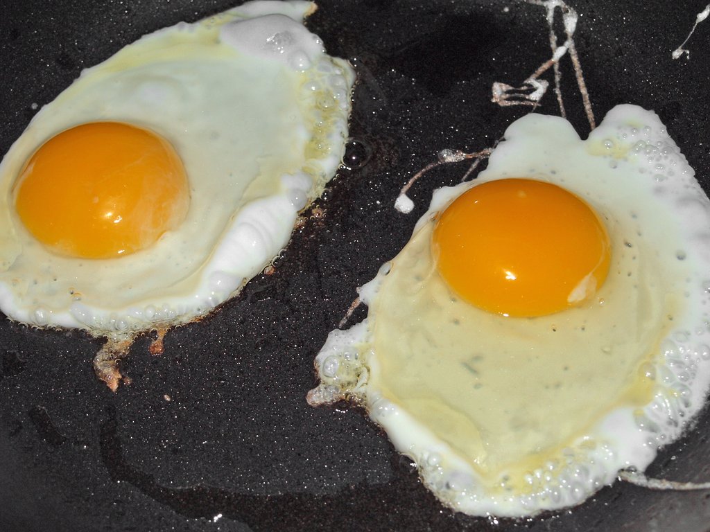 Deux œufs au plat pas encore tout à fait coagulés dans une poêle
