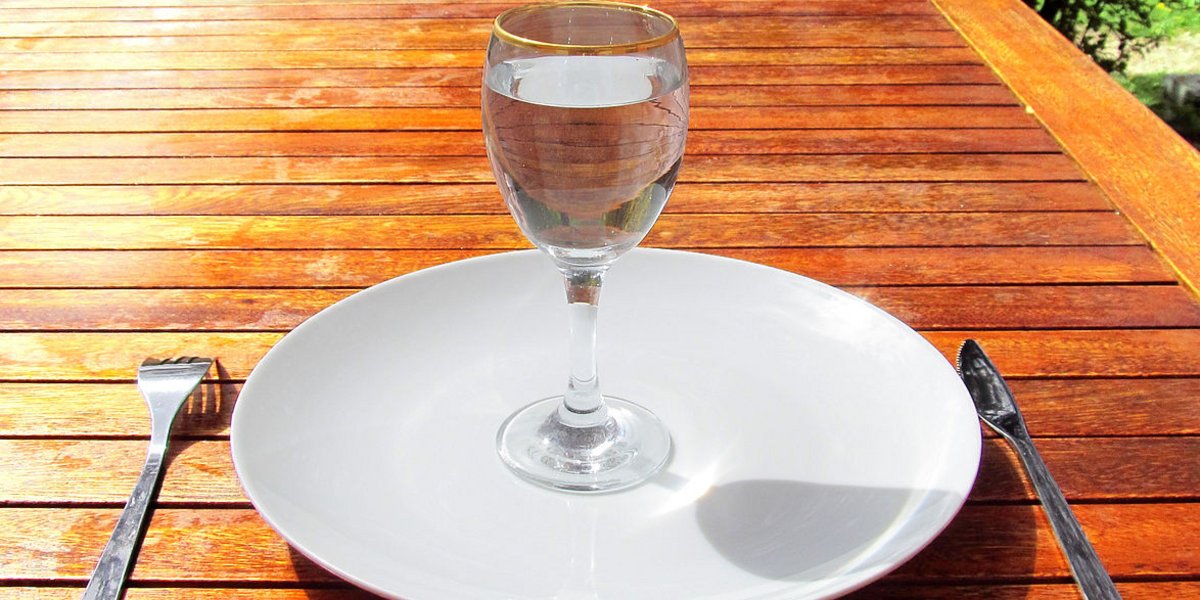 Leerer Teller mit Wasserglas