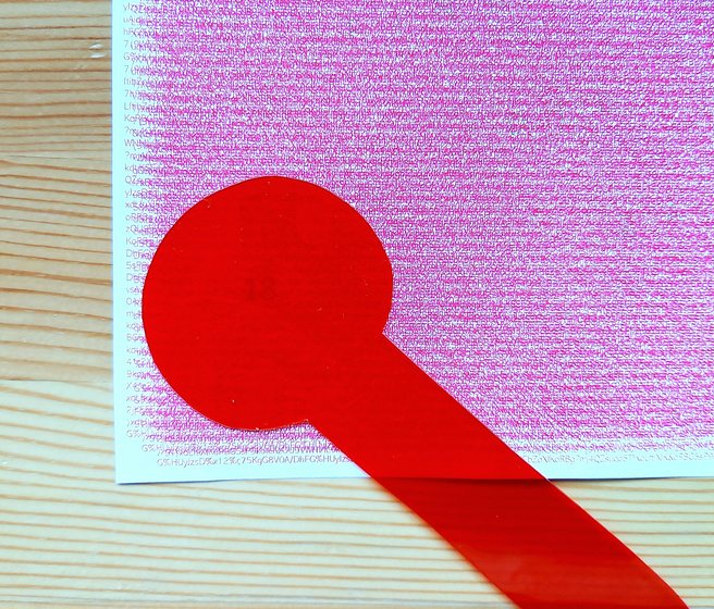 Carte avec brouillage rouge, avec une loupe rouge en feuilles de plastique posée dessus
