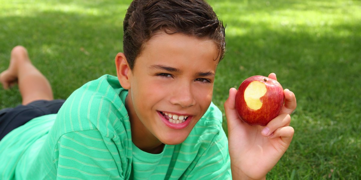 Jeune qui mange une pomme