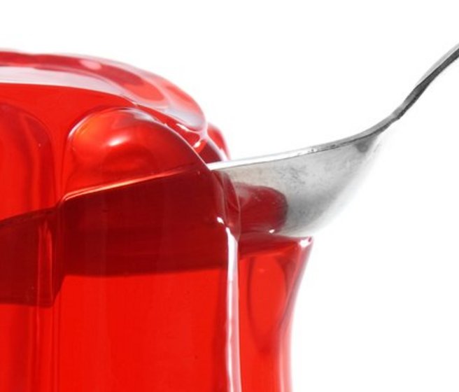 Une cuillère vue en transparence à travers un pudding de gélatine