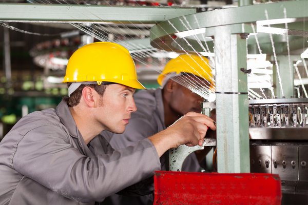 Zwei Mechaniker reparieren einen Webstuhl