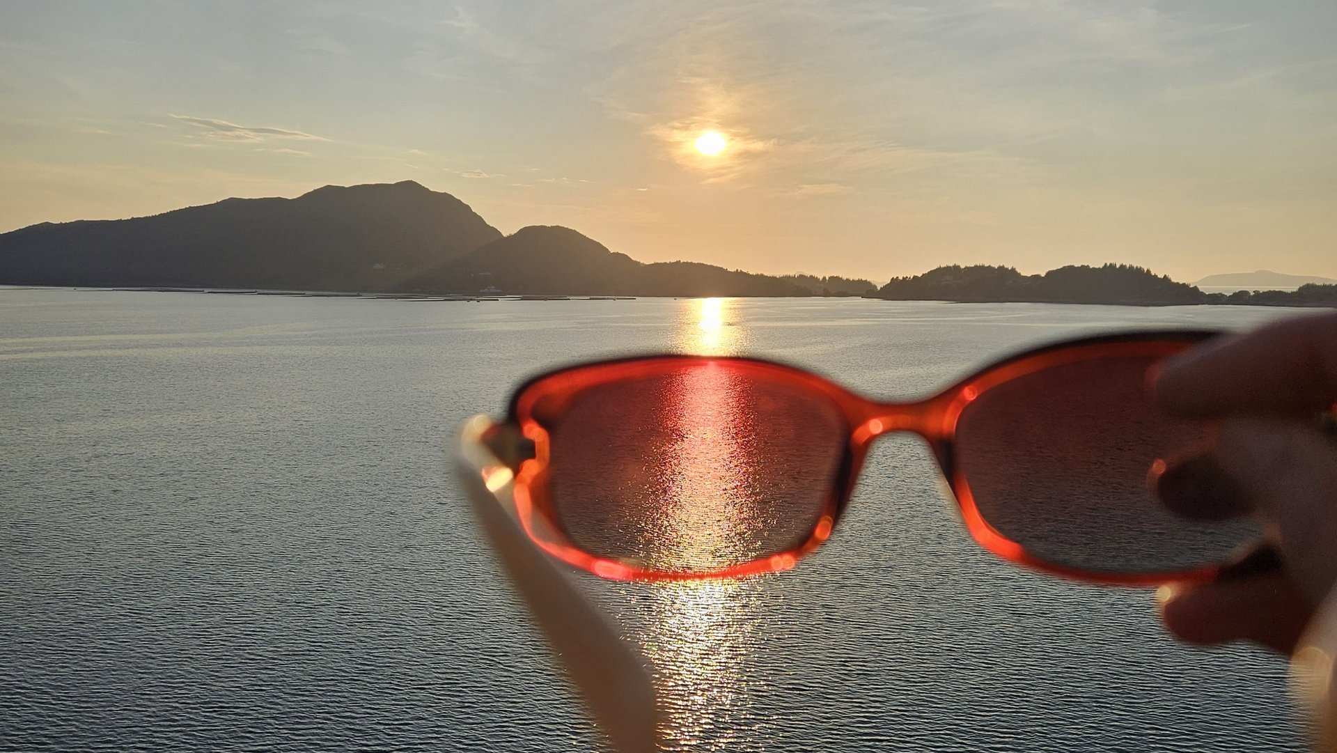Licht der tief stehenden Sonne über dem Meer durch eine Sonnenbrille betrachtet