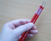 Deux crayons attachés ensemble par du ruban adhésif