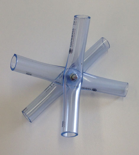 Un connecteur composé de trois morceaux de tubes en PVC, assemblés avec une vis et un écrou.